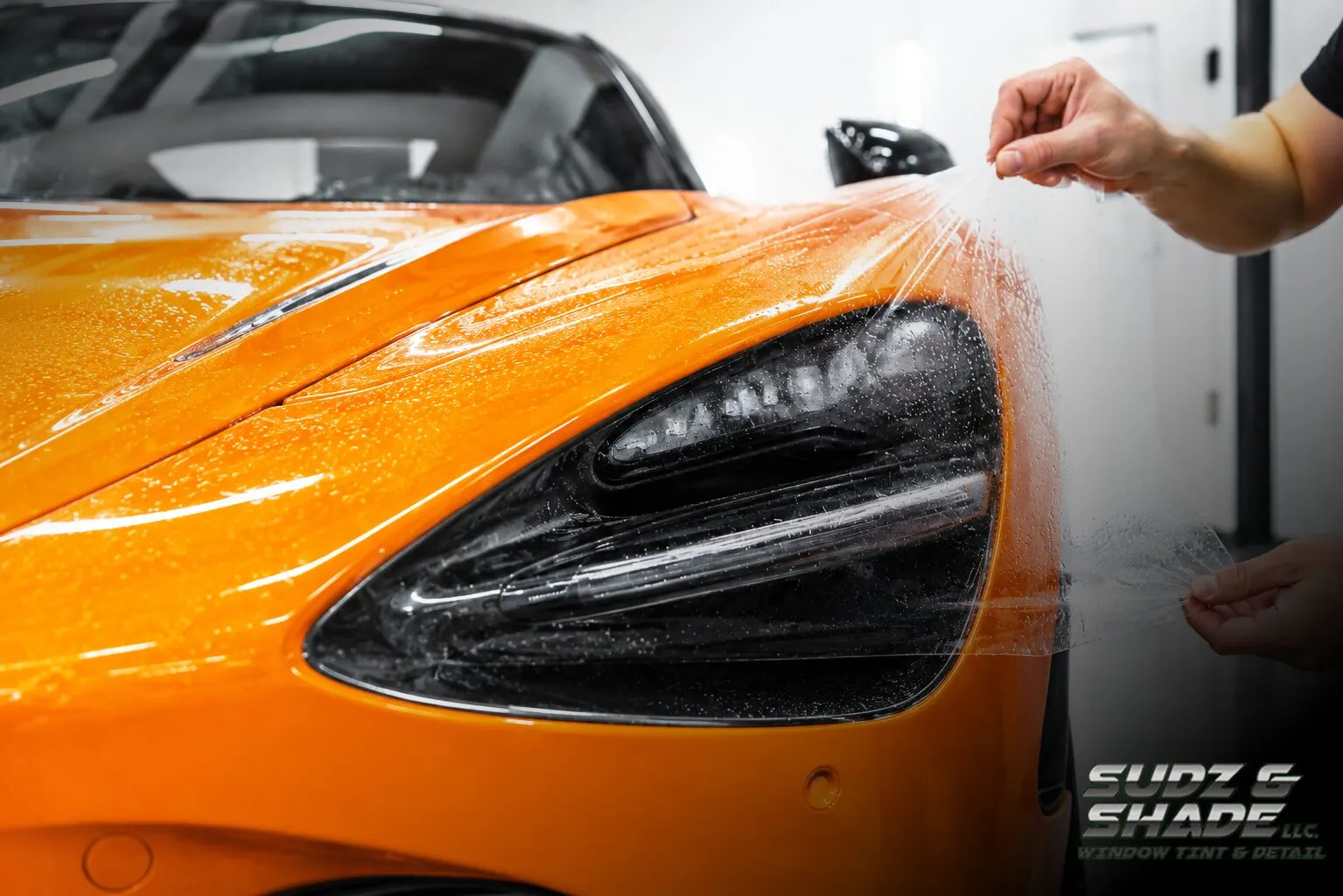 Paint protection film being installed on an orange McLaren in Scottsdale, Arizona
